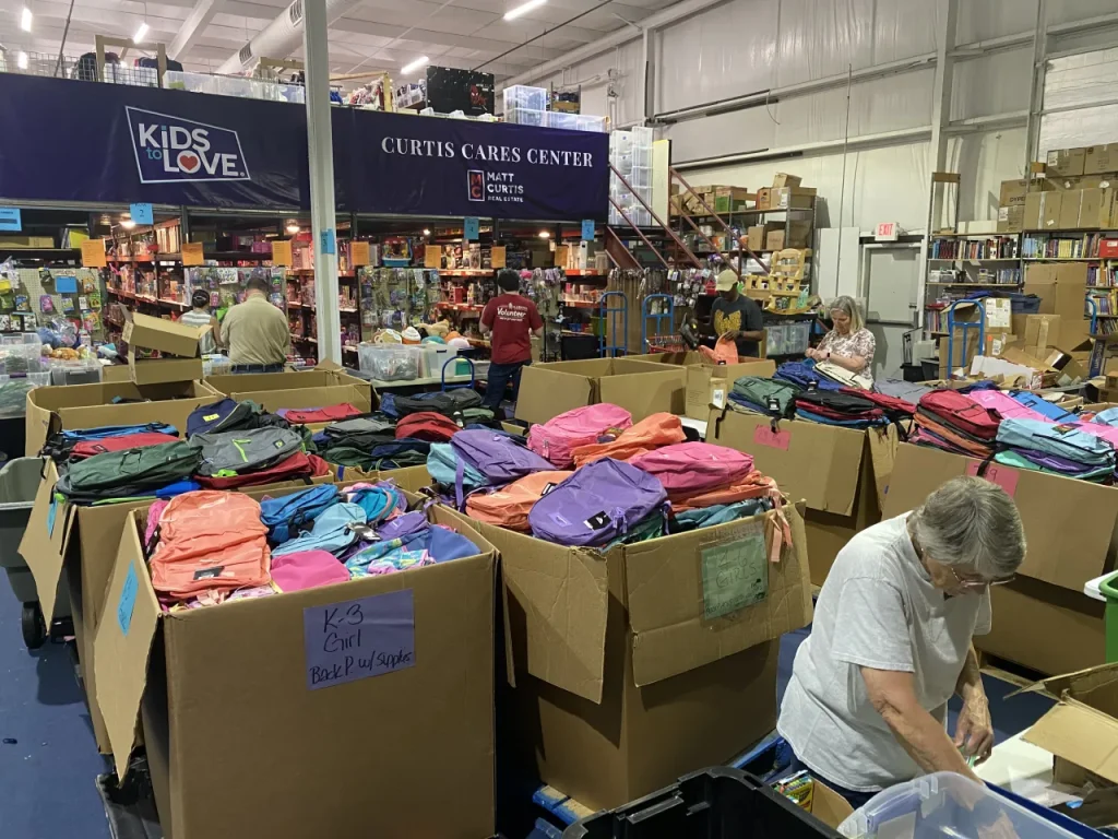 Kids to Love volunteers pack thousands of backpacks for foster care drive