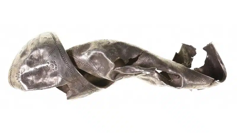 A decorative silver fragment found in Germany, along with the hoard of Roman-era coins.